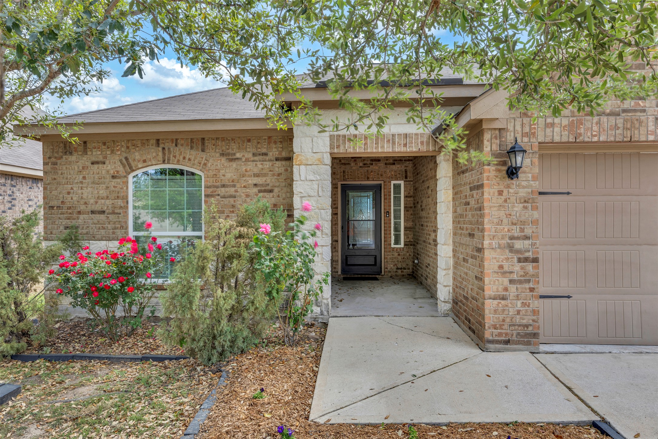 13213 Clara Martin Road Manor, TX 78653 - Photo 4 of 38 Entrance to property with an attached garage, brick siding, and roof with shingles