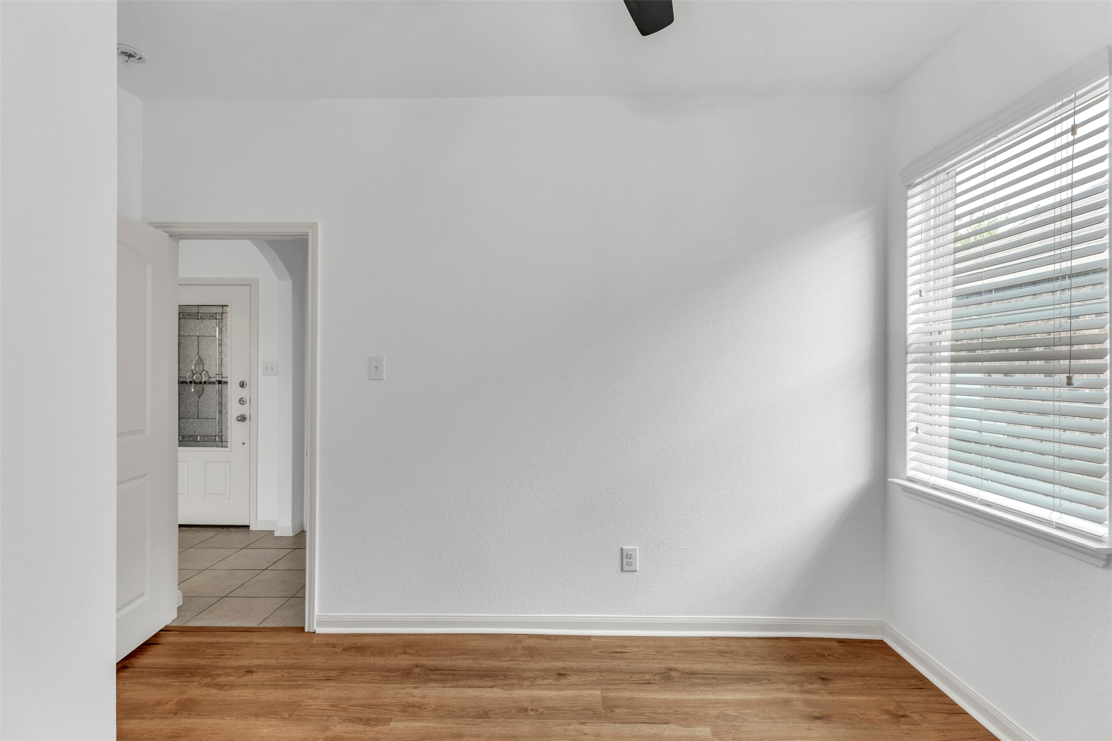 13213 Clara Martin Road Manor, TX 78653 - Photo 10 of 38 Empty room featuring light wood-style floors, arched walkways, and a ceiling fan