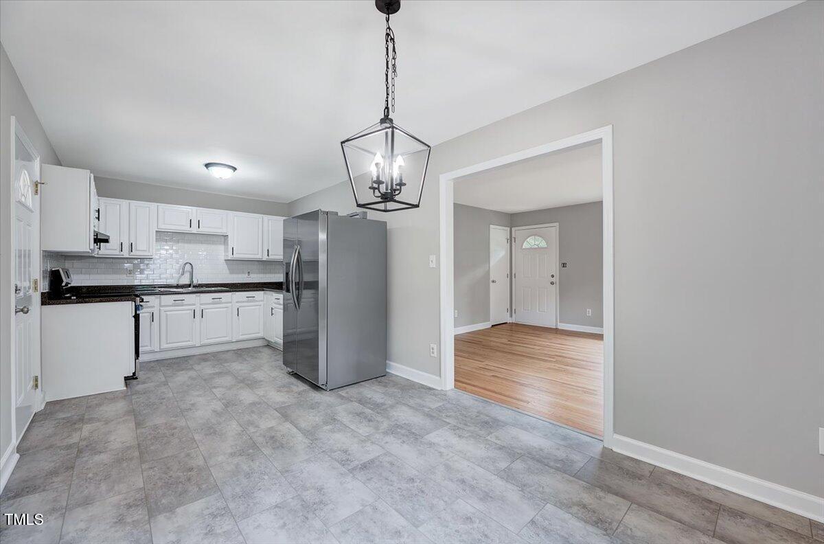 a view of a kitchen with refrigerator and wooden floor