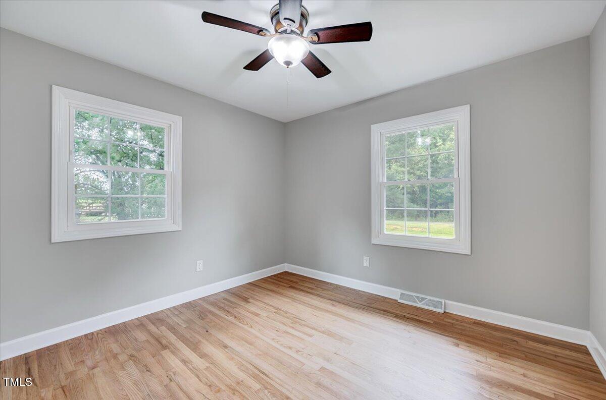 592 Perdues Road Louisburg, NC 27549 - Photo 11 of 27 a view of empty room with wooden floor and fan