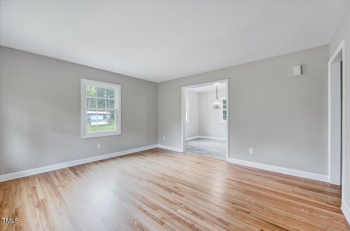 592 Perdues Road Louisburg, NC 27549 - Photo 9 of 27 an empty room with wooden floor and windows