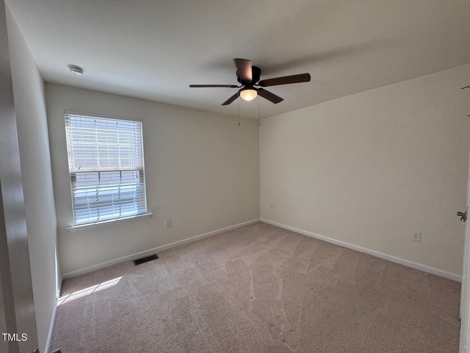 1205 Elliott Ridge Lane Morrisville, NC 27560 - Photo 24 of 32 an empty room with a window and a fan