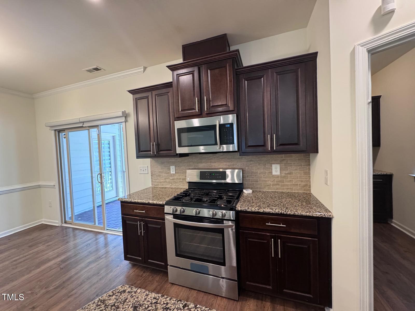 1205 Elliott Ridge Lane Morrisville, NC 27560 - Photo 27 of 32 a kitchen with granite countertop wooden cabinets and stainless steel appliances