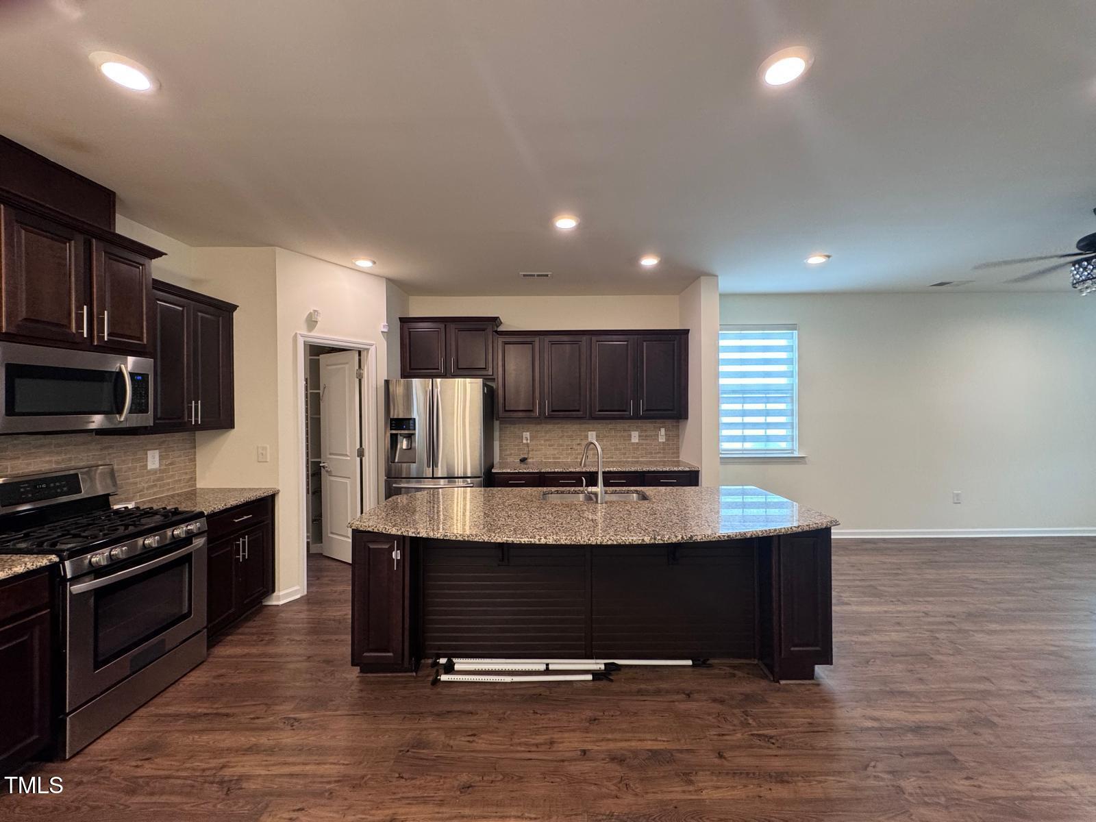 1205 Elliott Ridge Lane Morrisville, NC 27560 - Photo 5 of 32 a view of kitchen with stainless steel appliances kitchen island granite countertop a stove and a sink