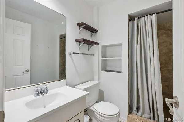 a bathroom with a sink a toilet and shower