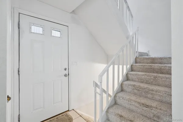 a view of staircase with white walls and windows