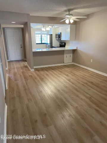 a view of a kitchen with a sink and wooden floor
