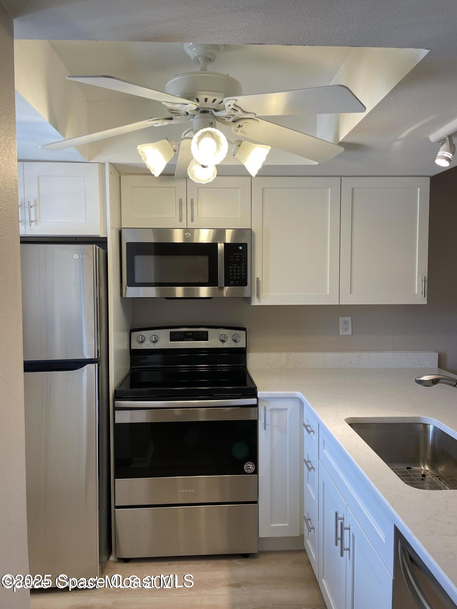 1720 Murrell Road, Unit 217 Rockledge, FL 32955 - Photo 6 of 24 a kitchen with a sink stainless steel appliances and cabinets