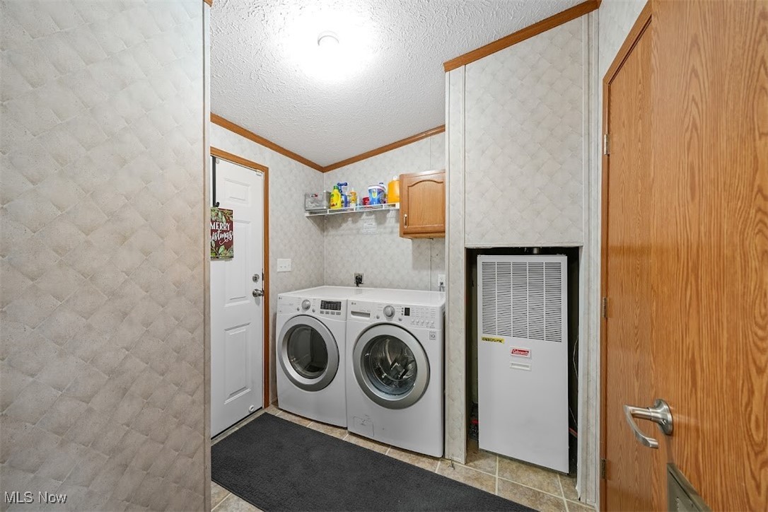 17296 Old State Road Middlefield, OH 44062 - Photo 15 of 44 Laundry area featuring washer and dryer, light tile patterned flooring, cabinets, and a textured ceiling