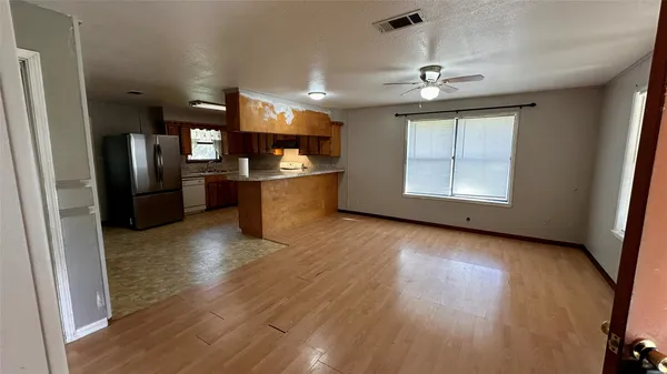 a view of a kitchen with a sink and refrigerator