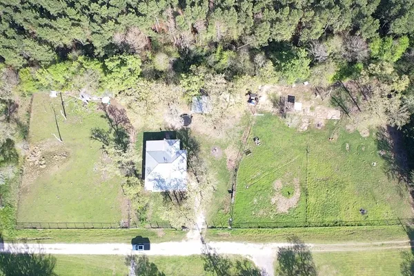 an aerial view of a residential houses with yard