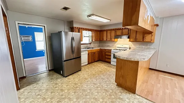 a kitchen with stainless steel appliances granite countertop a refrigerator and a stove