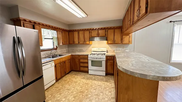 a kitchen with stainless steel appliances granite countertop a sink stove and refrigerator