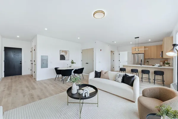 a living room with furniture and a view of kitchen