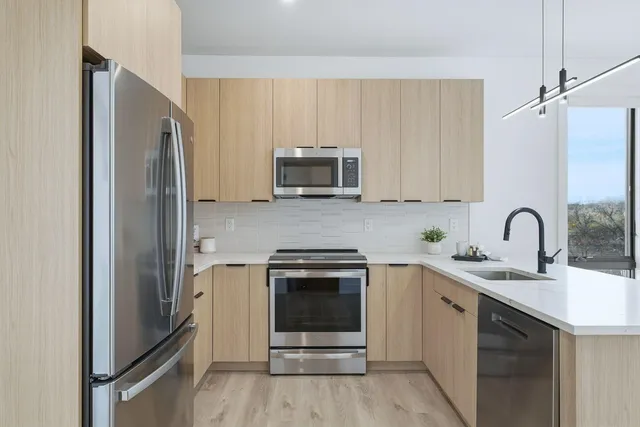 a kitchen with stainless steel appliances granite countertop a refrigerator and a stove top oven