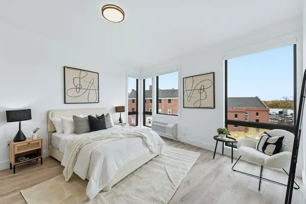 a bedroom with a bed a couch and painting on the wall