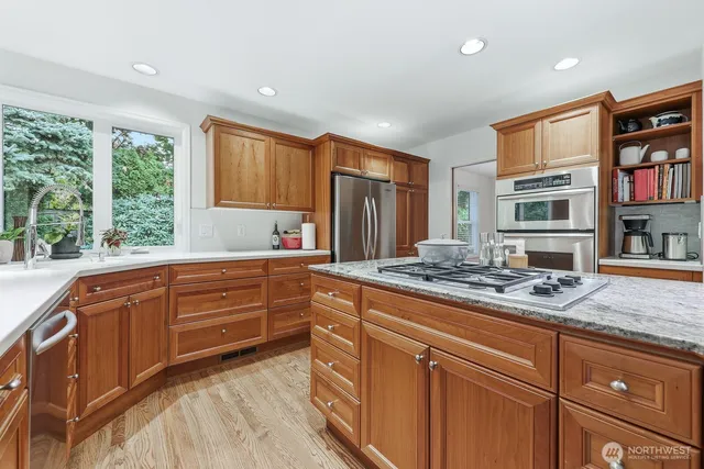 a kitchen with stainless steel appliances granite countertop a stove sink and cabinets