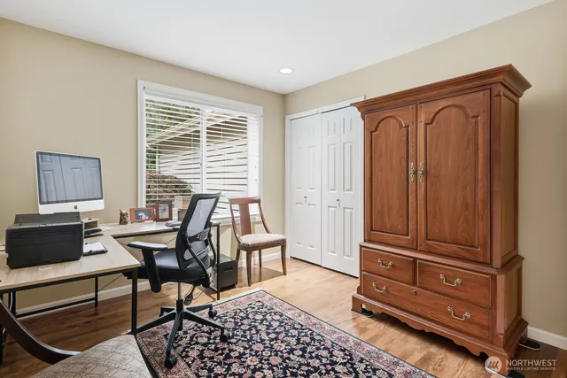 a view of a workspace with furniture and a window