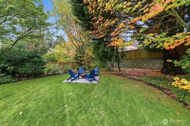 a view of a backyard with table and chairs and a large tree