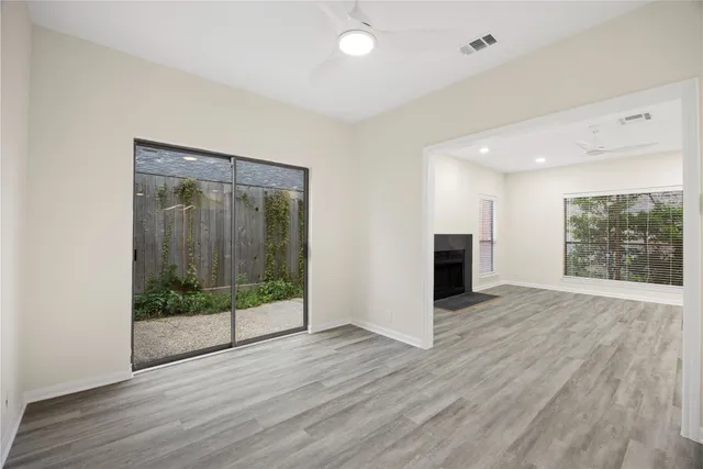 an empty room with wooden floor and windows