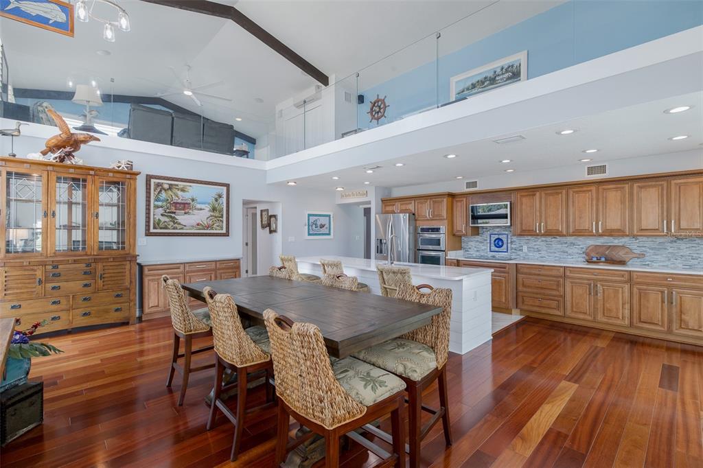 5040 Waterside Drive Port Richey, FL 34668 - Photo 11 of 58 a kitchen with a dining table chairs cabinets wooden floor and appliances