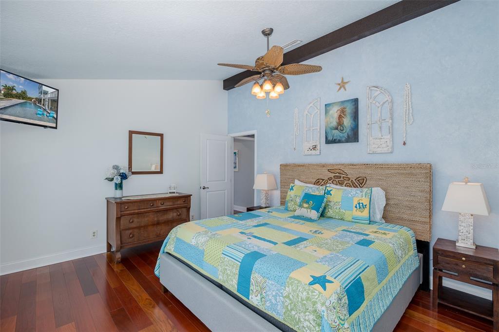 5040 Waterside Drive Port Richey, FL 34668 - Photo 19 of 58 a bedroom with a bed a dresser and wooden floor