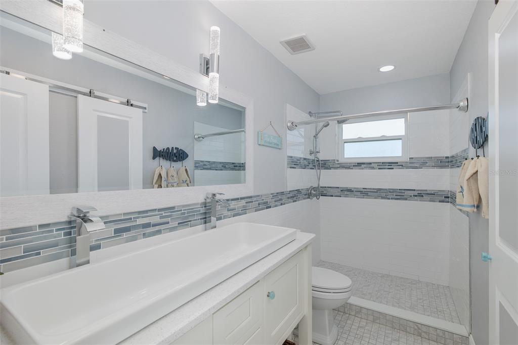5040 Waterside Drive Port Richey, FL 34668 - Photo 27 of 58 a bathroom with a sink a toilet a mirror and shower