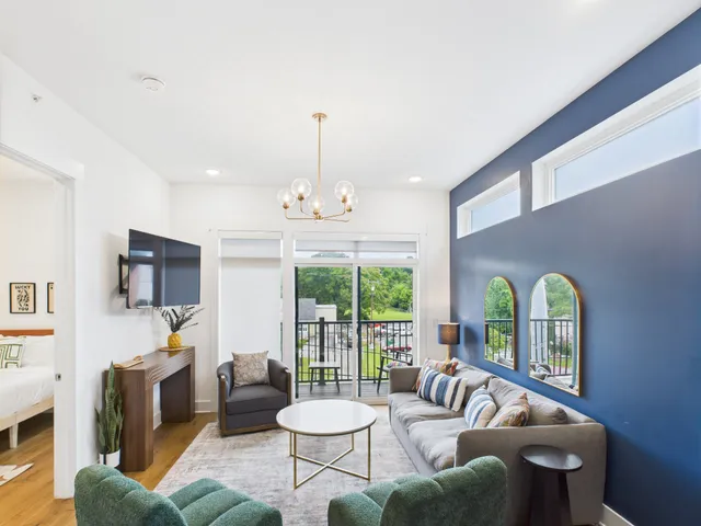 a living room with furniture and a floor to ceiling window