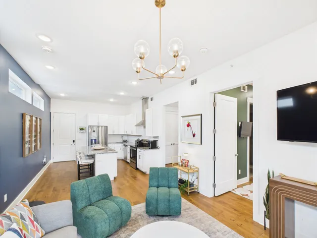 a living room with furniture kitchen view and a flat screen tv