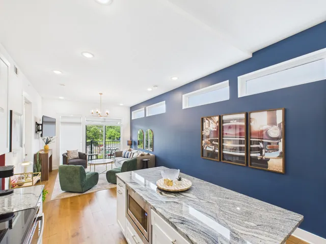 a kitchen with stainless steel appliances wooden floor dining table and chairs