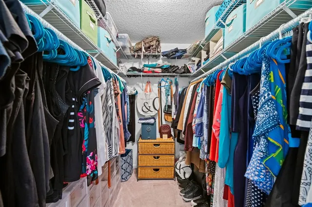 a view of walk in closet with clothes