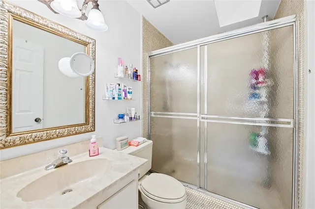 a bathroom with a sink vanity mirror and toilet