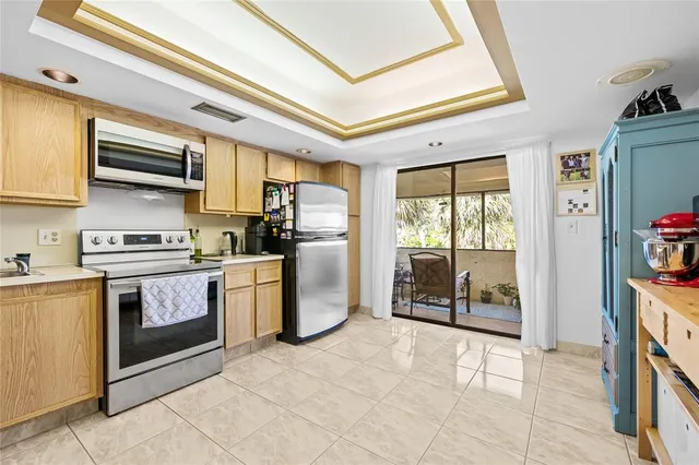 a kitchen with a refrigerator a stove top oven a sink and a window