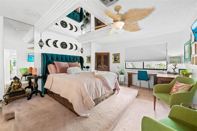 a spacious bedroom with a bed a couch and a chandelier