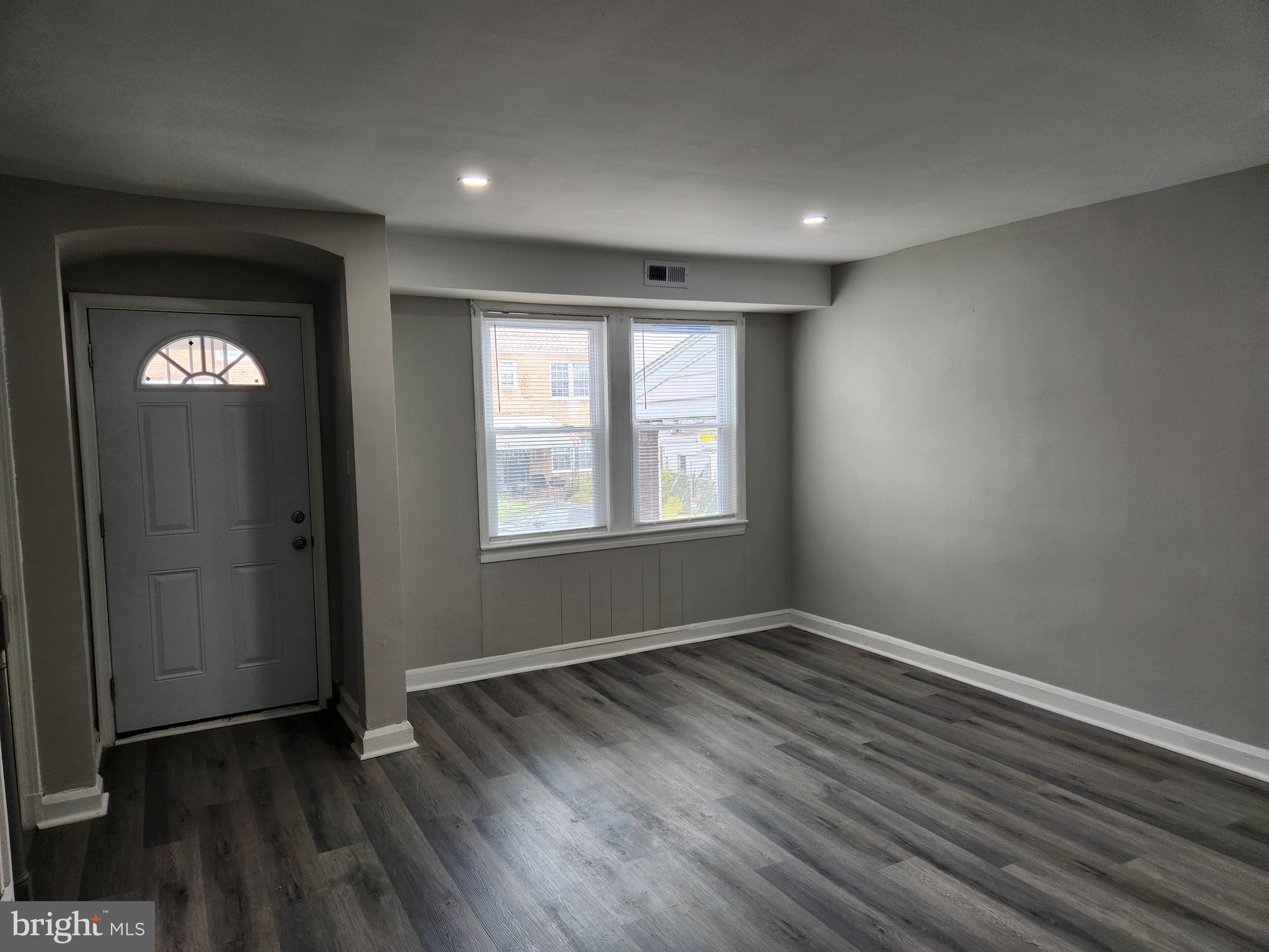 4113 Century Road Baltimore, MD 21206 - Photo 2 of 27 a view of an empty room with wooden floor and a window