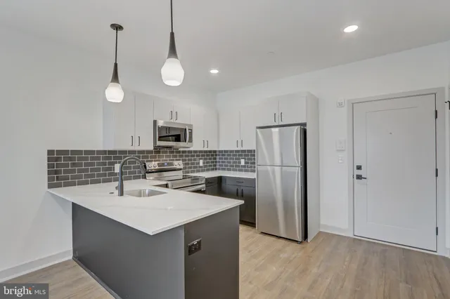 a kitchen with a sink a microwave a refrigerator and cabinets