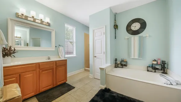 a bathroom with a double vanity sink mirror and bathtub
