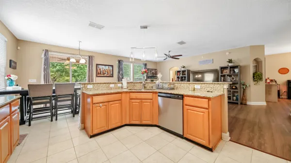 a large kitchen with stainless steel appliances kitchen island granite countertop a sink and cabinets