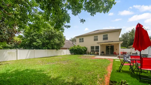 a view of a house with a backyard and a patio