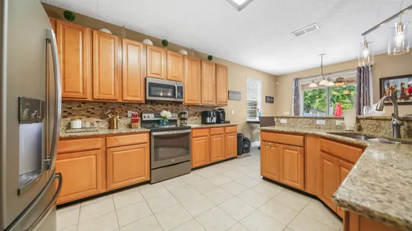 a kitchen with stainless steel appliances granite countertop a stove a sink dishwasher and a microwave oven with cabinets