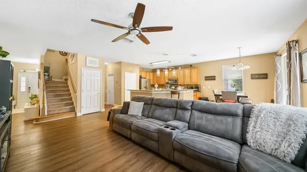 a living room with furniture ceiling fan and a wooden floor