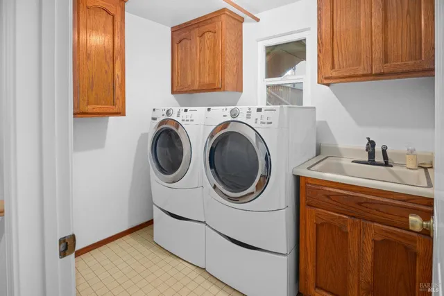 a utility room with sink dryer and washer