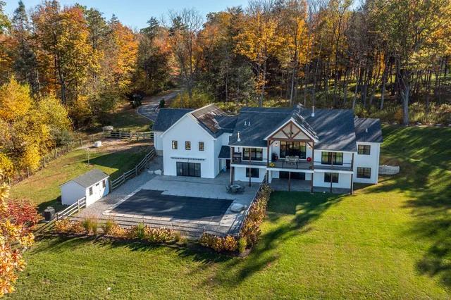 a aerial view of a house with swimming pool next to a yard