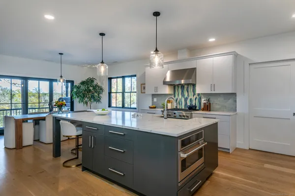 a kitchen with a stove a sink and a refrigerator with wooden floor