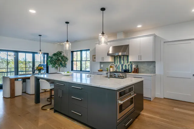 a kitchen with a stove a sink and a refrigerator with wooden floor