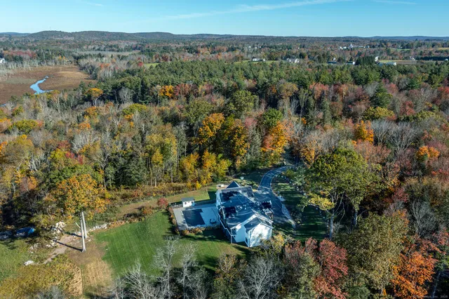 an aerial view of residential house with outdoor space and trees all around