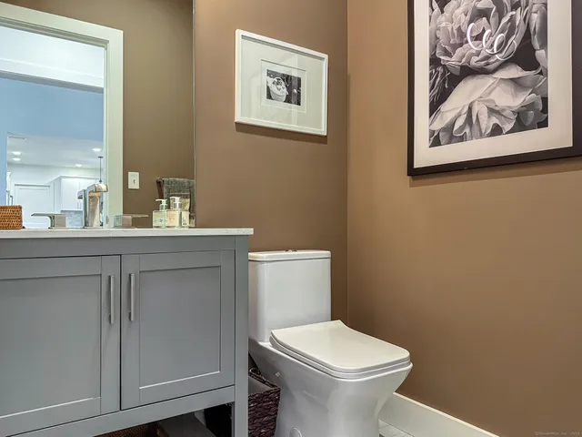a bathroom with a toilet a sink and mirror
