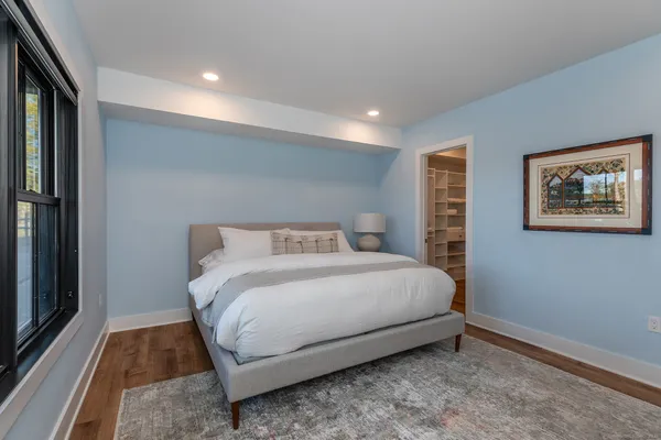 a bedroom with a bed and a painting on the wall