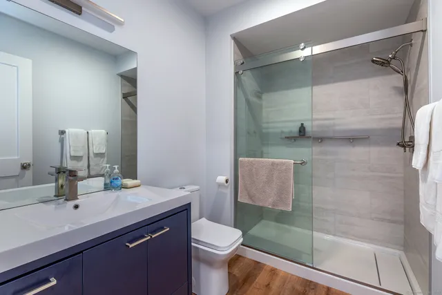 a bathroom with a sink a toilet and shower