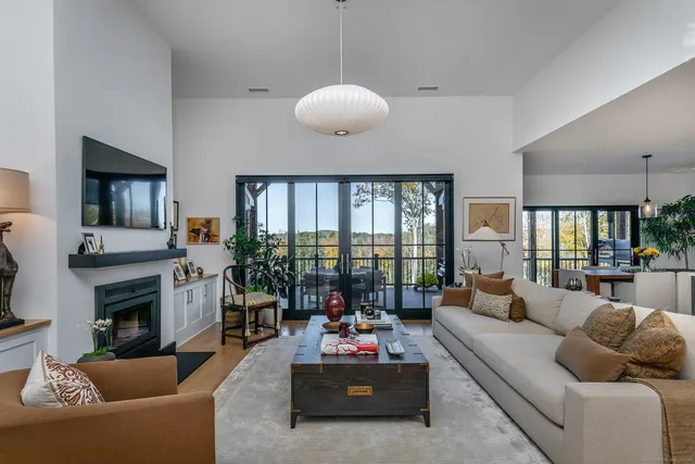 a living room with furniture fireplace and a large window